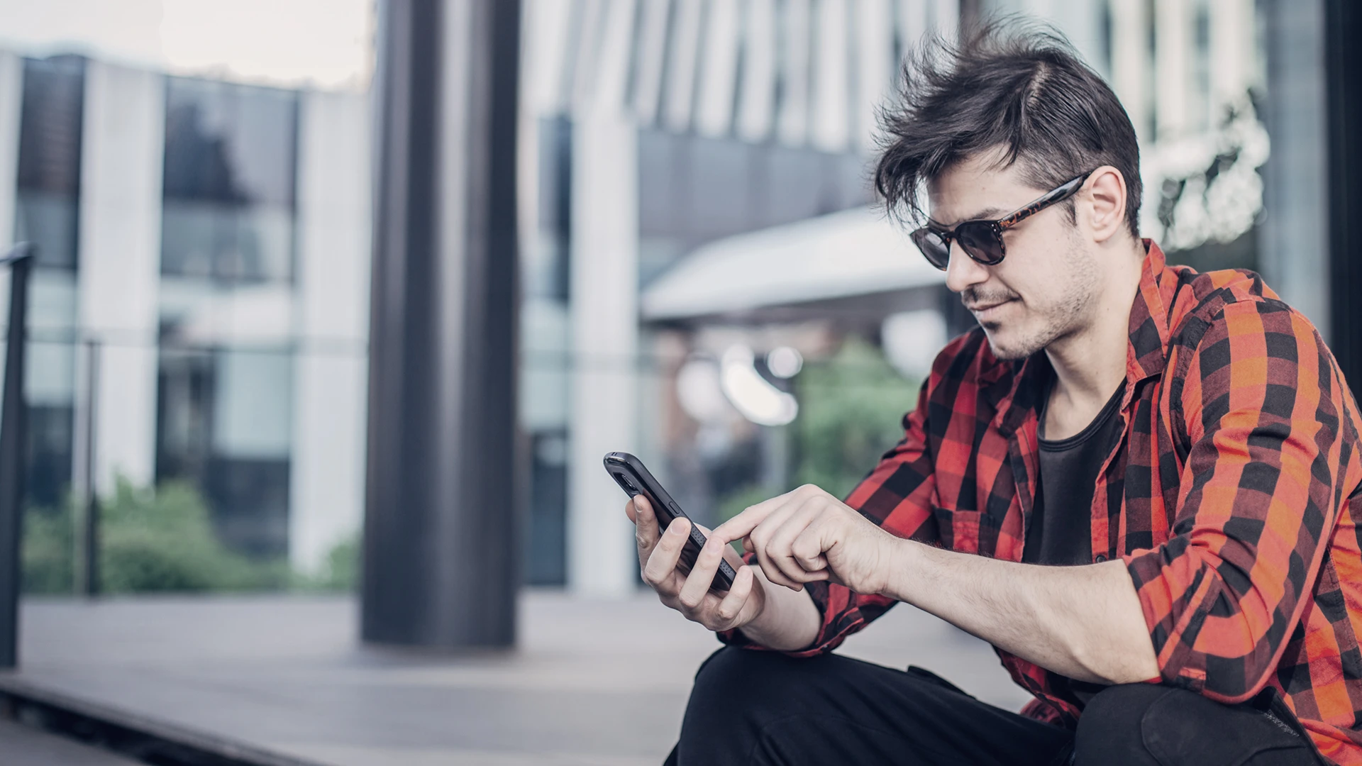 /man-with-glasses-looking-at-phone.