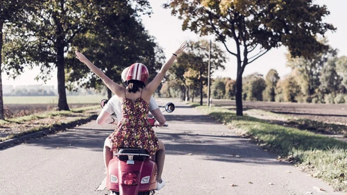 Two people riding a scooter.
