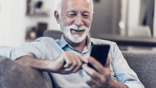Senior man smiling at phone